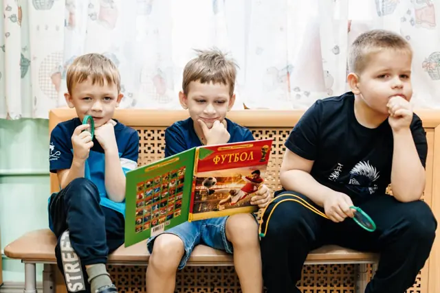 Мальчики читают книгу про футбол
