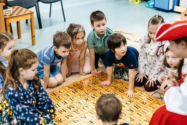 Дети собирают слова из букв на ковре